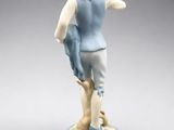 porcelain figurine of a boy with a blue vest and white shirt