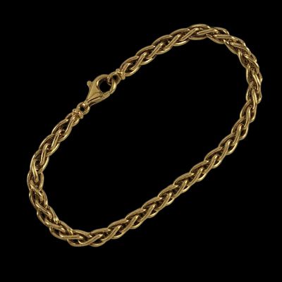 un bracelet en or avec un motif tressé sur fond noir
