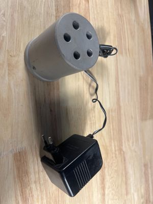 une photo en noir et blanc montrant une lampe posée sur une table en bois