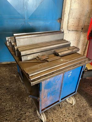 a blue cart with a bunch of wood on it