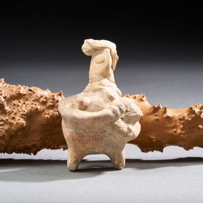 une statue de femme assise au sommet d'un rocher