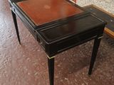 une table noire avec un plateau marron et une chaise rouge