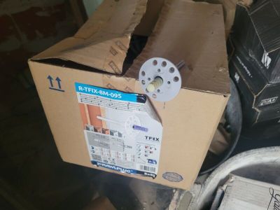 une boîte en carton sur laquelle est posée une lampe, posée elle-même sur une pile de boîtes