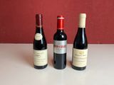 trois bouteilles de vin posées sur une table, l'une à côté de l'autre