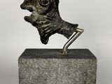 bronze sculpture of a dog ' s head on top of a block