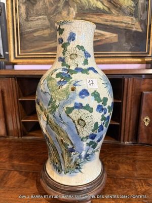 un vase posé sur une table devant un tableau
