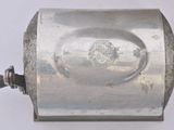 a small silver object on a white surface