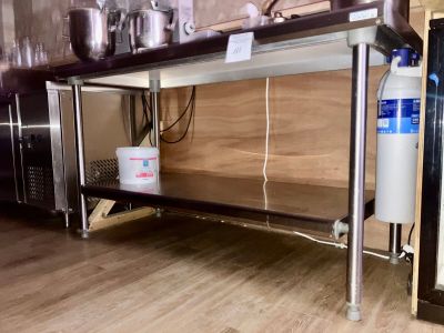 une table en acier inoxydable sur laquelle est posé un distributeur d'eau