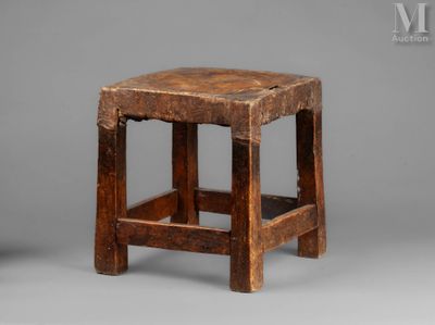 an old wooden stool sitting on top of a gray surface