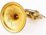 a gold plate with a flower on it on a white surface