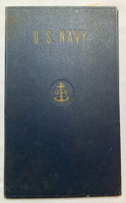 an old navy book sitting on top of a white table