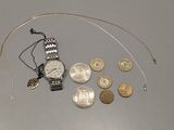 une montre en argent et quelques pièces de monnaie posées sur une table
