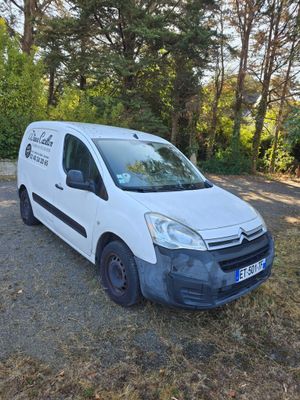 La camionnette est garée sur le bord de la route, dans les bois.