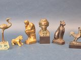 cinq statues en bronze représentant des animaux et des oiseaux, sur un fond bleu