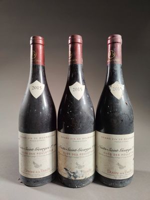 trois bouteilles de vin posées sur une table l'une à côté de l'autre