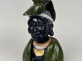 une image représentant une figurine d'un homme portant un chapeau sur la tête