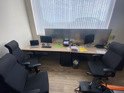 un bureau avec deux ordinateurs et deux chaises dans une pièce