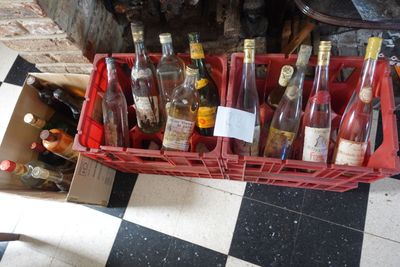 de nombreuses bouteilles de vin dans une caisse rouge posée sur un sol à carreaux