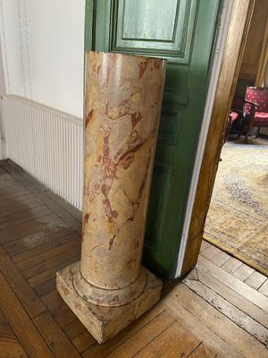 a marble column in the corner of a room