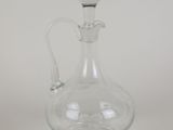 a clear glass bottle with a handle on a white background