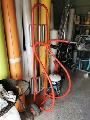 a red hand truck that is next to a stack of surfboards