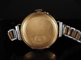 a close up of a gold watch on a black surface
