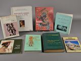 Plusieurs livres sont posés sur une table devant un fond gris.