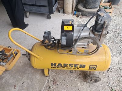 un petit compresseur d'air posé par terre à côté d'autres outils