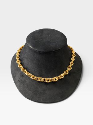 un chapeau noir orné d'une chaîne dorée