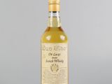 une bouteille de whisky posée sur une table blanche