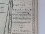 an old book with a black and white cover on a white table