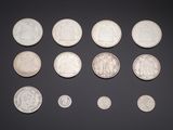 an assortment of silver coins on a black surface