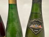 three bottles of wine are lined up on a white surface