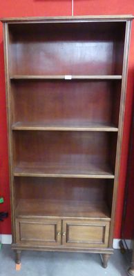 une bibliothèque en bois avec deux tiroirs et une porte