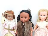 three dolls sitting next to each other on a table