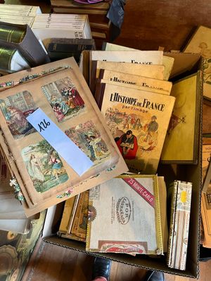 une boîte remplie de vieux livres posée par terre