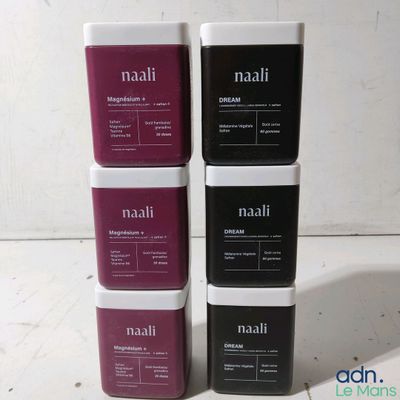 three boxes of nail polish sitting on top of a white table