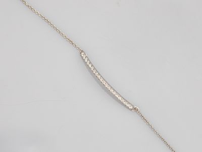 a close up of a silver necklace on a white surface