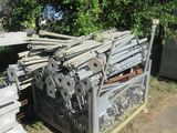 un gros tas de bois posé par terre à côté d'une clôture