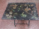 une table noire sur laquelle sont peints des oiseaux et des fleurs