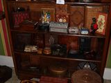 une bibliothèque sur laquelle sont posés de nombreux objets, dans une pièce