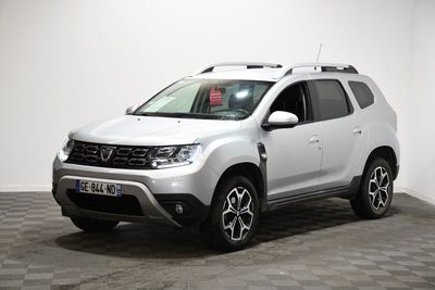 la dacia blanche est garée dans une pièce au sol en damier