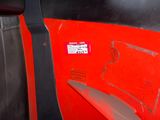 a close up of a red car door with a sticker on it