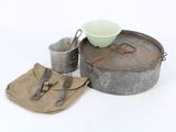 a metal pan with a green bowl and utensils next to it
