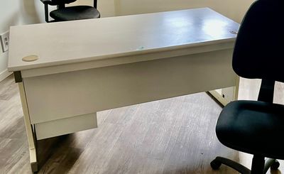 un bureau avec une chaise et une fenêtre dans un coin
