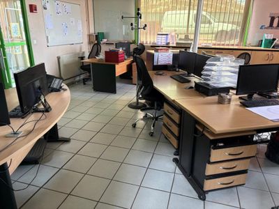 une salle où se trouvent de nombreux bureaux et ordinateurs
