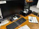 un bureau sur lequel se trouvent un ordinateur, un clavier, une souris et d'autres objets