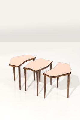 un ensemble de trois petites tables avec des pieds en bois et un plateau en cuir rose