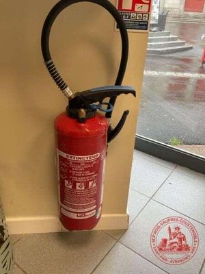 un extincteur fixé au mur d'un immeuble