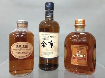 trois bouteilles d'alcool posées les unes à côté des autres sur une table